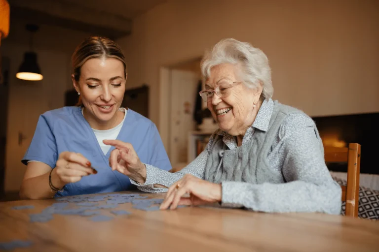 caregiver and senior with dementia working on a puzzle